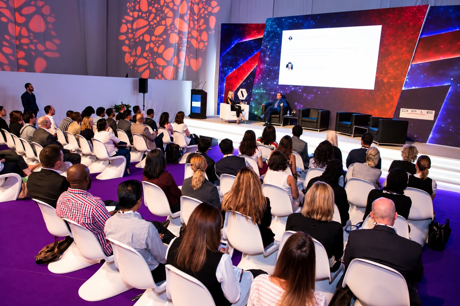 A seated audience at a stage session during the INDEX exhibition