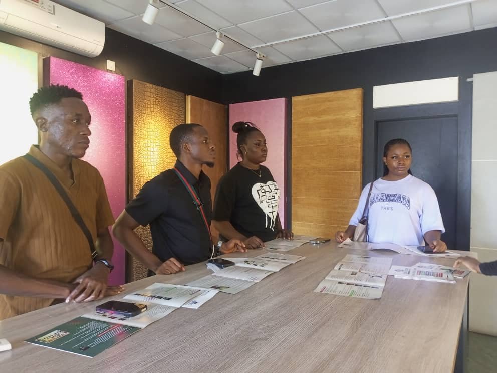 Students at a supplier showroom counter reading product literature beside finish samples